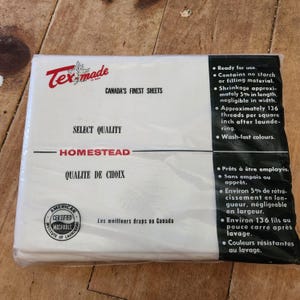 Puede incluir: Un paquete de sábanas blancas Tex-made Homestead en envoltorio de plástico transparente. La etiqueta incluye el texto Canada's Finest Sheets, Select Quality, y detalles como 136 hilos por pulgada cuadrada y un sello de lavado certificado.
