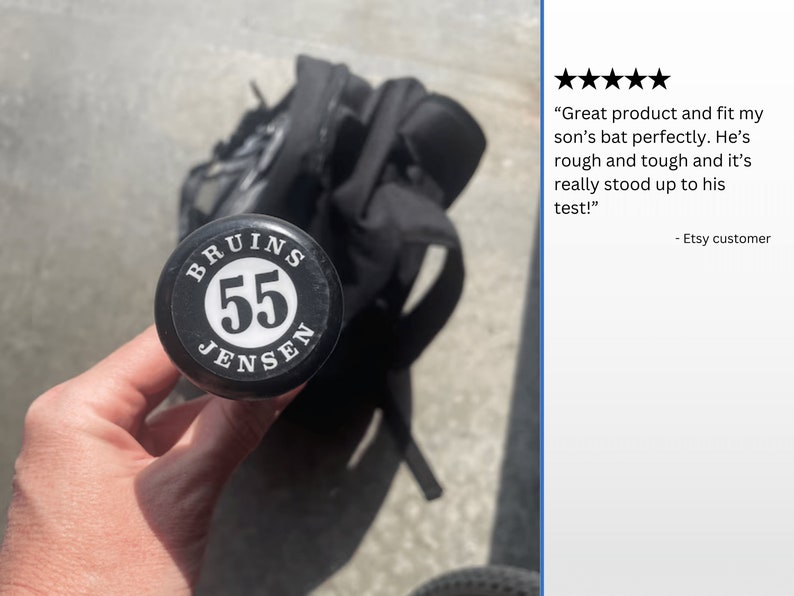 Pode incluir: Close-up de um taco de beisebol preto com um adesivo branco que diz "BRUINS 55 JENSEN".