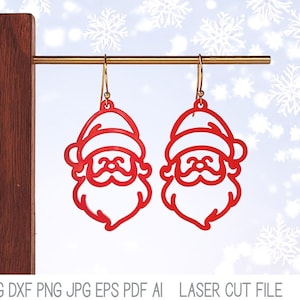 May include: A pair of bright red, laser-cut Santa Claus face earrings hanging from a gold-toned metal bar. The earrings feature a cutout design of Santa with a hat, mustache, and beard. Text at the bottom reads: Wispy Willow Designs SVG DXF PNG JPG EPS PDF AI LASER CUT FILE.