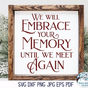 May include: A wooden sign with the text "We will embrace your memory until we meet again" in red lettering. The sign is sitting on a table with a green plant in the background.