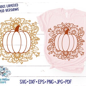 Op de afbeelding: Een lichtroze t-shirt met een bruin pompoenontwerp omringd door bloemen. Het ontwerp wordt ook als een aparte afbeelding getoond. De tekst "INCLUDES LAYERED AND SOLID VERSIONS" staat bovenaan. De tekst onderaan luidt "SVG • DXF • EPS • PNG • JPG • PDF".