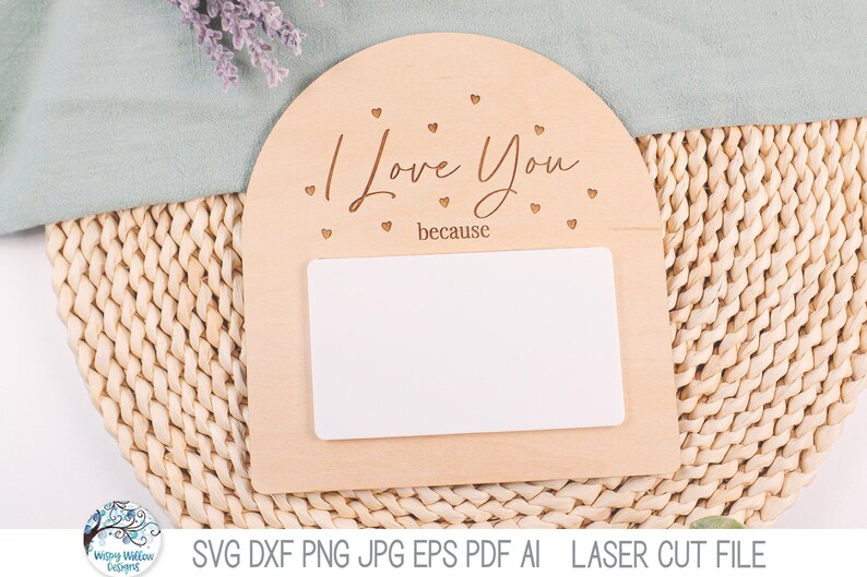 May include: An arched light-colored wooden sign featuring the engraved text I Love You because and small heart cutouts. A blank white rectangular insert is positioned in the center of the wooden plaque, providing a space for custom messages.