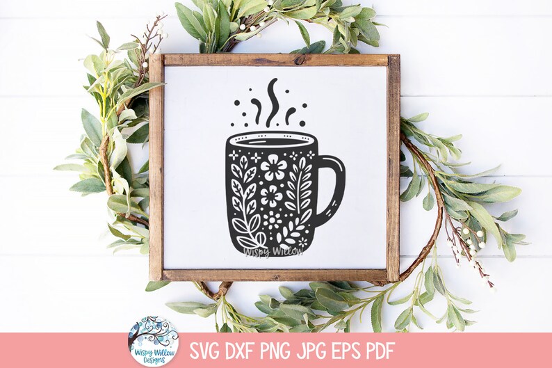 May include: A black and white illustration of a coffee mug with a floral design and steam rising from the top. The mug is on a white background.