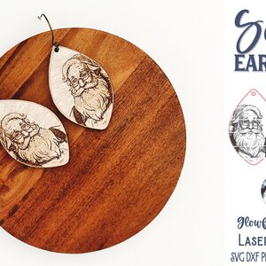 Puede incluir: Pendientes de madera en forma de l&aacute;grima con una ilustraci&oacute;n grabada con l&aacute;ser de Santa Claus con barba y gafas. Los pendientes incluyen ganchos de metal. El texto en la imagen dice Santa EARRINGS, Glowforge Tested LASER CUT FILE y SVG DXF PNG JPG EPS PDF AI.