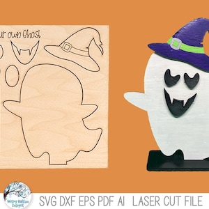 May include: A laser-cut wooden craft kit labeled Build your own Ghost, featuring a flat sheet with cutouts for a ghost body, witch hat, and facial features, alongside an assembled, painted white ghost figure wearing a purple hat.