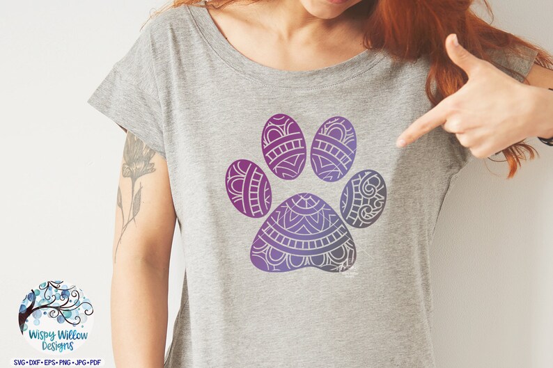 May include: A gray t-shirt with a purple and blue mandala paw print design.