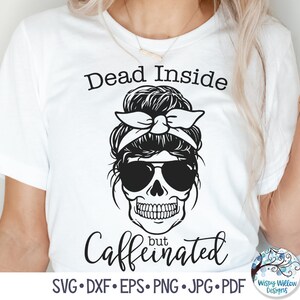 May include: A white t-shirt with a black and white graphic of a skull with sunglasses and a bandana. The text "Dead Inside but Caffeinated" is written below the graphic.