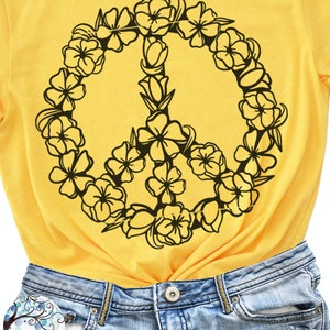 May include: A yellow t-shirt with a black peace sign made of flowers. The text "PEACE SIGN SVG FILE" is at the bottom of the image.