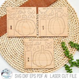 May include: Three square light-colored wooden panels, each laser-cut with a pumpkin outline and various facial features. The text Build your own Jack-O-Lantern is engraved at the top of each panel, alongside a rectangular base piece.