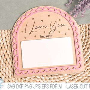 May include: An arched wooden sign with a pink scalloped border, featuring the engraved text "I Love You because" and small heart icons. The sign includes a large, blank white rectangular space for writing messages, designed as a laser cut file.