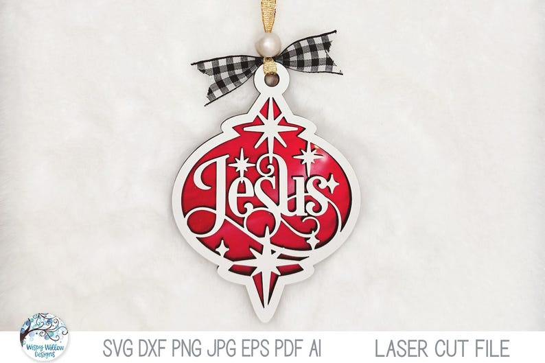 May include: A teardrop-shaped Christmas ornament featuring a white cutout frame with the word Jesus in script, layered over a red background with star accents. It is topped with a black and white buffalo plaid bow and a gold hanging cord.