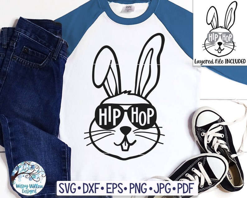 May include: White and blue raglan shirt with a black graphic of a bunny wearing sunglasses that spell "HIP HOP." The shirt is paired with blue jeans and black sneakers. The image also includes a layered file graphic.