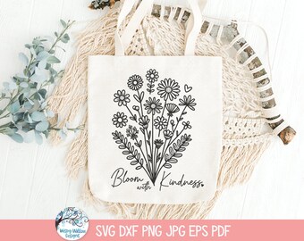 Pode incluir: Uma sacola de lona na cor creme com uma ilustração de linhas pretas de um buquê de flores silvestres. O design inclui várias flores semelhantes a margaridas e caules com folhas, acompanhadas pelo texto Bloom with Kindness em cursivo.