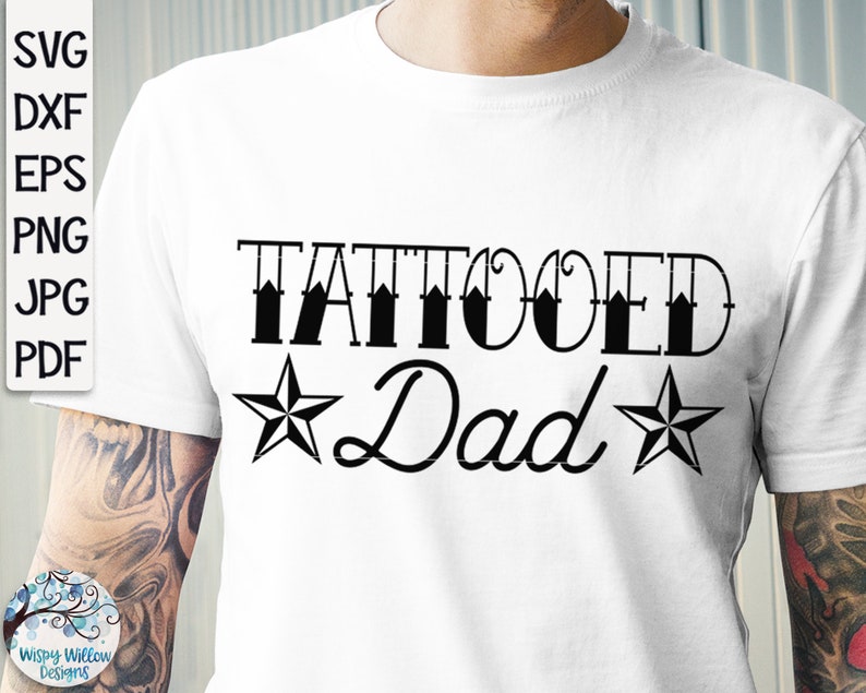 May include: A white t-shirt featuring the black text TATTOOED Dad with a star on each side of the word Dad. The text SVG, DXF, EPS, PNG, JPG, PDF is visible on the left side. The design is printed on the front of the shirt.