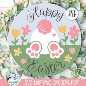 Peut inclure: Un design graphique circulaire avec le texte Happy Easter en écriture noire. L'illustration montre une queue de lapin blanche et deux pattes aux coussinets roses sur un fond d'herbe verte avec des fleurs jaunes et roses sous un ciel bleu clair.