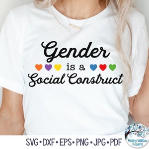 May include: White t-shirt with the text "Gender is a Social Construct" in black cursive font. A row of six rainbow hearts are above the text.