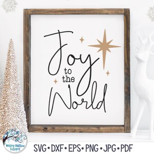 May include: A framed sign with a white background and a dark brown wooden frame. The text reads Joy to the World in black cursive lettering. There are three gold-colored starburst icons of varying sizes positioned near the text.