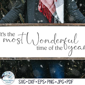 May include: A rectangular wooden sign with a dark brown frame and a white background featuring the black text It's the most Wonderful time of the year. The sign is held horizontally and includes a circular logo with the text Wispy Willow Designs.