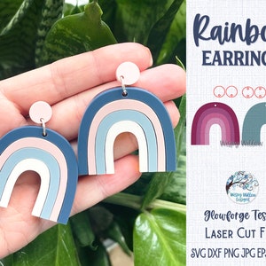 May include: A pair of rainbow-colored earrings in shades of blue, pink, and white. The earrings are shaped like rainbows with a rounded arch. The earrings are made of a smooth, glossy material. The image includes the text "Rainbow Earrings" and "Glowforge Tested Laser Cut File SVG DXF PNG JPG EPS PDF AI".