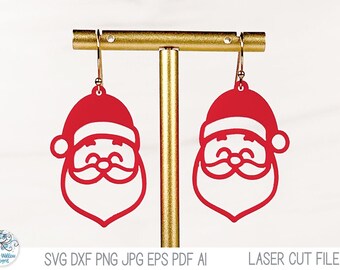 May include: A pair of red Santa Claus face earrings hanging from a gold-toned T-bar display stand. Each earring features a cutout design of a smiling Santa with a hat, mustache, and beard, suspended by gold-toned metal earring hooks.