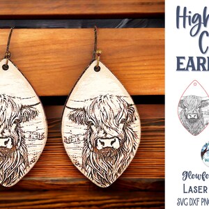 May include: A pair of teardrop-shaped wooden earrings featuring a laser-engraved Highland cow illustration. The text Highland Cow Earrings, Glowforge Tested Laser Cut File, SVG DXF PNG JPG EPS PDF AI, and Wispy Willow Designs is visible.