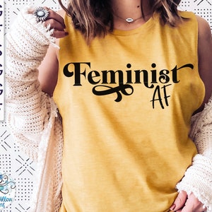 May include: A yellow sleeveless shirt with the text "Feminist AF" printed in black.