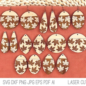 Puede incluir: Un conjunto de 12 pendientes de madera cortados con láser con un diseño de hojas de otoño. Los pendientes son de varias formas, incluyendo círculos, óvalos y gotas. Las hojas son de color marrón claro con un contorno blanco.