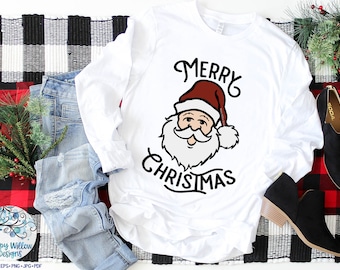 May include: White long-sleeved t-shirt with a black and red illustration of Santa Claus and the text "Merry Christmas".