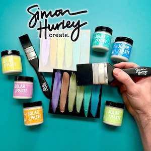 Puede incluir: Una variedad de botes de pintura Solar Paste en varios colores, con muestras de pintura y pinceles. Los botes son blancos con tapas y etiquetas negras. El texto "Simon Hurley create." es visible.