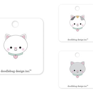 Op de afbeelding: Drie printbare cadeaulabels met schattige cartoonkatten met verschillende vachtkleuren. Elk label heeft een gat voor een touwtje en de tekst "doodlebug design inc." onderaan.