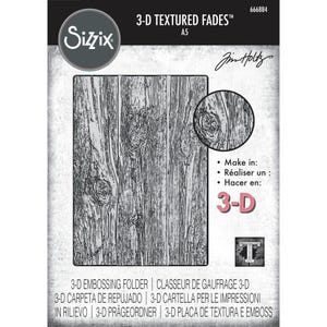 May include: A gray and white 3-D embossing folder with a wood grain texture. The Sizzix brand logo is in the upper left corner. The text "3-D TEXTURED FADES" and "A5" are at the top. The folder is designed for crafting.