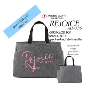 May include: A gray heather small tote bag with black handles. The bag features the embroidered pink text "Rejoice ALWAYS" and "PHIL 4:4". A smaller version of the same bag is shown to the right, featuring a side pocket holding a black bottle.