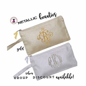 May include: Two zippered pouches with gold and silver glitter fabric. The pouches have a gold and silver embroidered monogram. The text "METALLIC beauties" is at the top of the image. The text "gold" and "silver" are below the pouches. The text "GROUP DISCOUNT available!" is at the bottom of the image.