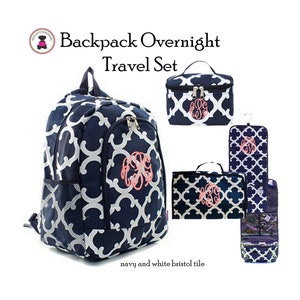 May include: A navy blue and white patterned overnight travel set with a backpack, a cosmetic bag, and a hanging toiletry bag. The set features a monogram in pink.