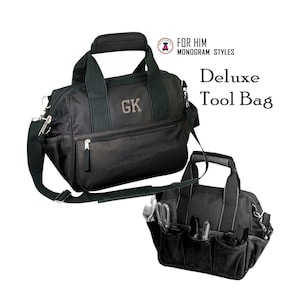 May include: Black canvas tool bag with a shoulder strap and two top handles. The bag has a zippered pocket on the front and a monogrammed "GK" on the front. The bag is labeled "Deluxe Tool Bag".