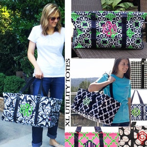 May include: Four large black and white tote bags with green, pink, and black and white patterns. The bags have black handles and are monogrammed with different letters. The bags are labeled "XL Utility Totes".
