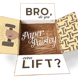 Puede incluir: Caja de cartón abierta con temática de levantamiento de pesas. La caja presenta el texto "BRO, do you even LIFT?" y una mano sosteniendo una mancuerna. El interior tiene un patrón de mancuernas y el logo de Paper Paisley.