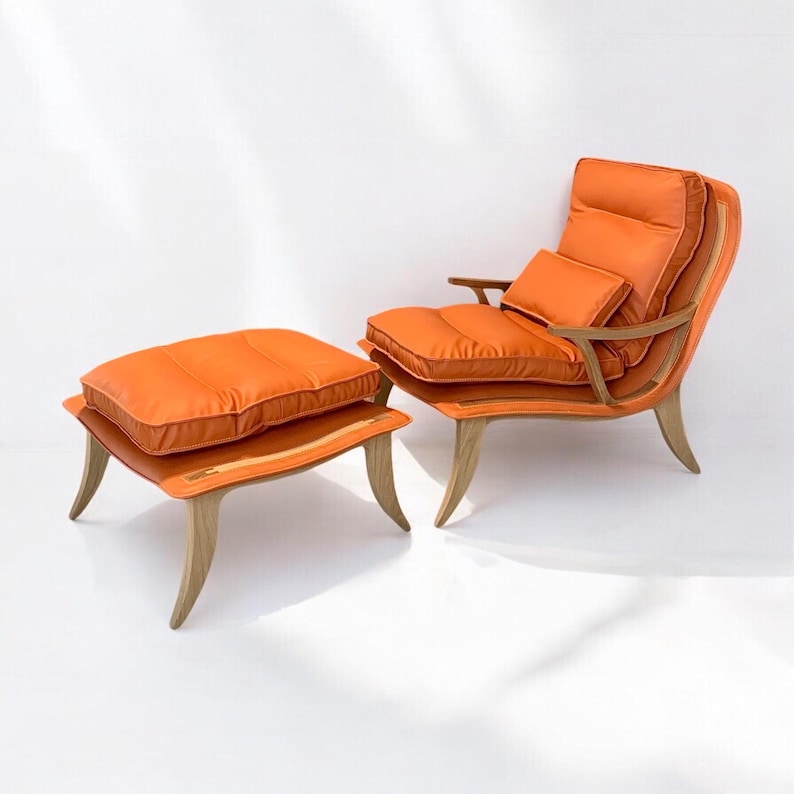 May include: An orange leather armchair with a matching footstool. The chair has a high back and a curved shape. The footstool has a square top and four legs.