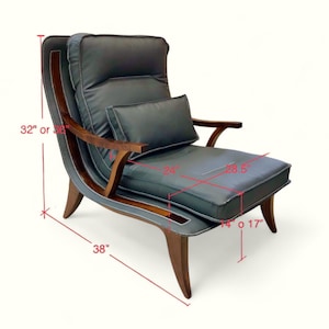 May include: A grey leather armchair with wooden arms and legs. The chair has a back cushion and a seat cushion. The chair is 32 inches tall and 38 inches wide. The seat is 24 inches deep and 28.5 inches wide.