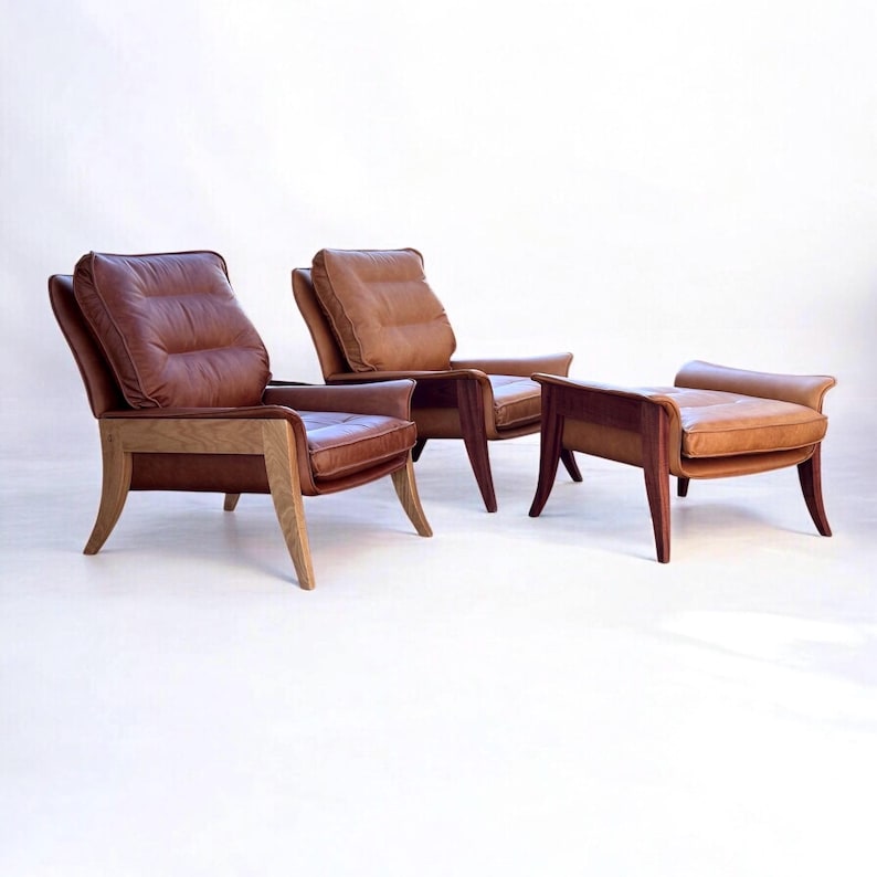 May include: Two brown leather armchairs with wooden frames and a matching brown leather ottoman with a wooden frame.
