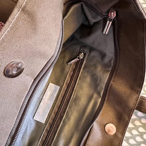 May include: A brown canvas tote bag with a zippered pocket and a label that reads "Cosmetica Ecologica".