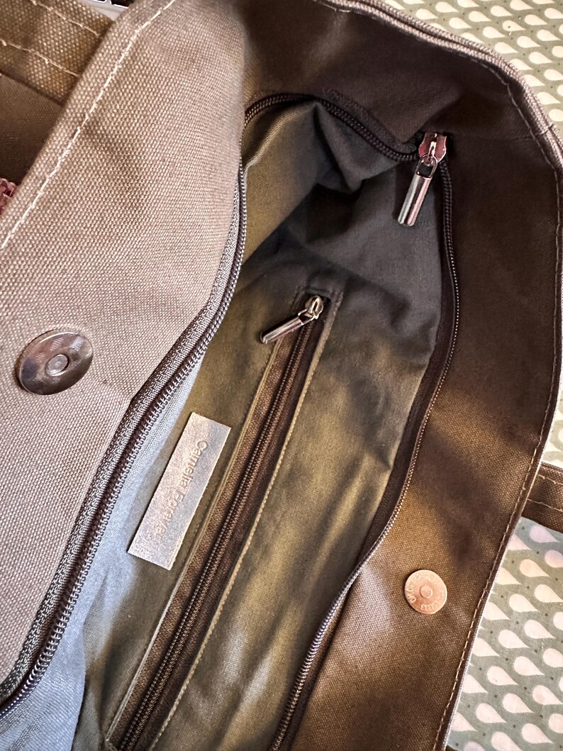 May include: A brown canvas tote bag with a zippered pocket and a label that reads "Cosmetica Ecologica".