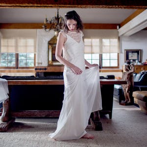 May include: A woman in a white lace dress with a long white skirt.