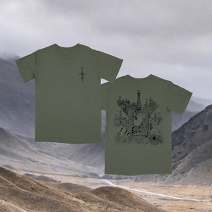 May include: A green t-shirt with a black graphic of a sword on the front and a black graphic of a city on the back.