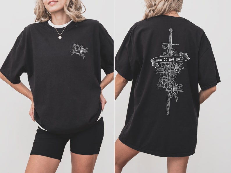May include: Black oversized t-shirt with a white floral design on the front and a sword with flowers and the text "you do not yield" on the back.