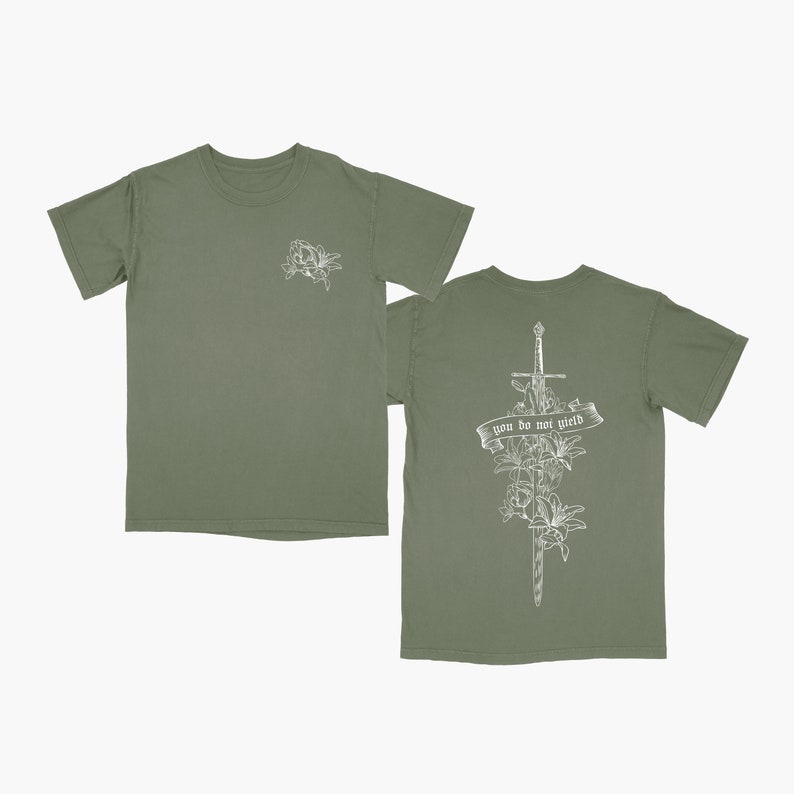 May include: A green t-shirt with a white floral design on the left chest and a sword with flowers and the text "you do not yield" on the back.