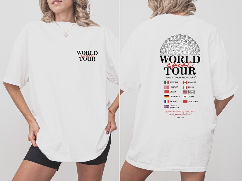 May include: White t-shirt with a graphic of the Epcot World Showcase logo and the text "World Epcot Tour" with flags representing different countries. The text "The World Showcase" is also included. The back of the shirt has the text "World Epcot Tour" with the text "A celebration of cultures and possibilities" and the year "EST 1982".