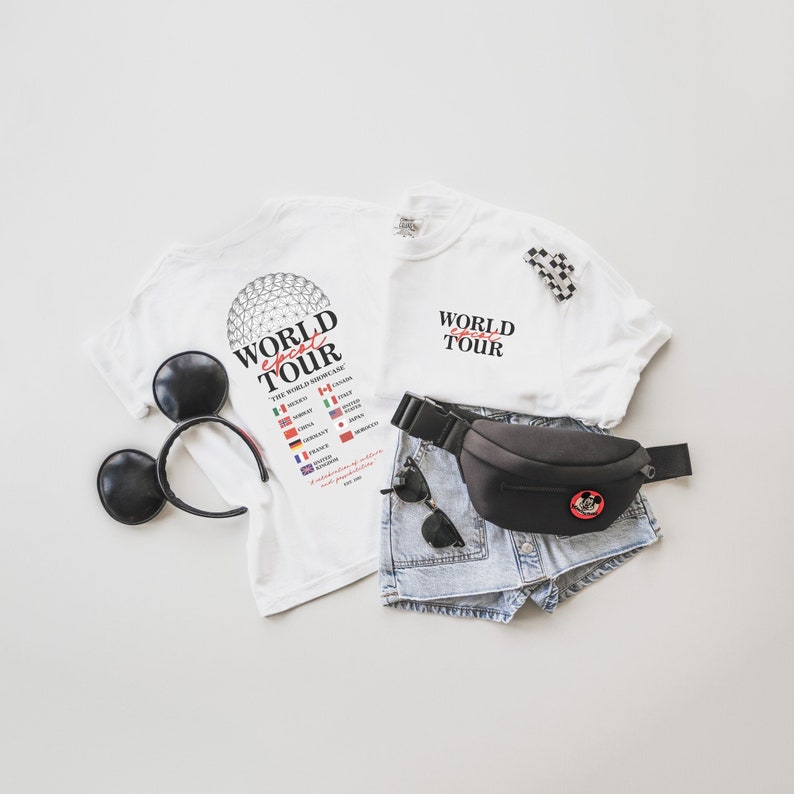May include: Two white t-shirts with the text "World Ghost Tour" and a list of countries. One shirt has a graphic of the Epcot Spaceship Earth. A black fanny pack with a Mickey Mouse graphic, a pair of denim shorts, and a pair of black Mickey Mouse ears.