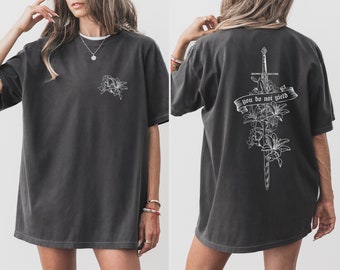 May include: A dark gray oversized t-shirt with a white floral design on the front and a sword with flowers and the text "you do not yield" on the back.