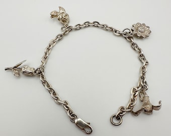 May include: Silver charm bracelet featuring a chain with a lobster clasp. The bracelet has four charms: a rose, a sunflower, a tulip, and a bellflower. The bracelet is displayed on a white background.